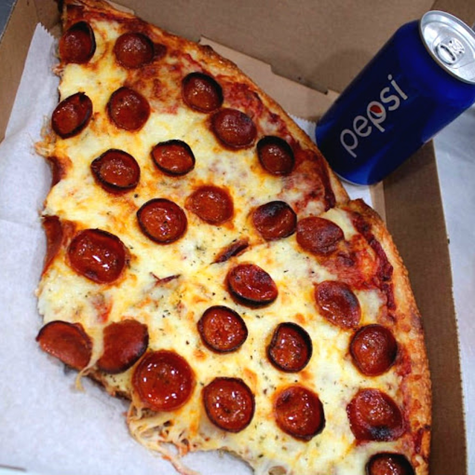 Two slices of Bozzy's pepperoni pizza and a blue Pepsi can in a cardboard box.