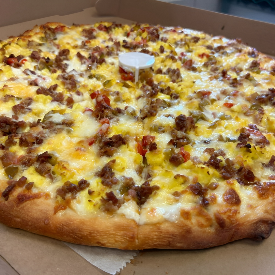 Bozzy's Pizzeria breakfast pizza with scrambled eggs, sausage, and peppers in a box.